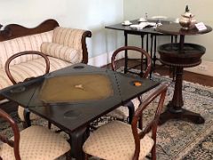 13 The tea sitting room has a wooden games table and a tea setting Devon House mansion Kingston Jamaica